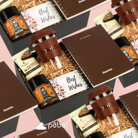 A set of gift hampers containing customized glass mugs, diaries, metal pens, flavored chocolates, and cards, arranged on a table.