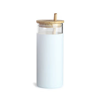 A sleek white glass tumbler with a bamboo lid and straw, featuring a removable silicone sleeve.