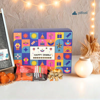 Colorful Diwali-themed gift box with decorative items on a table.