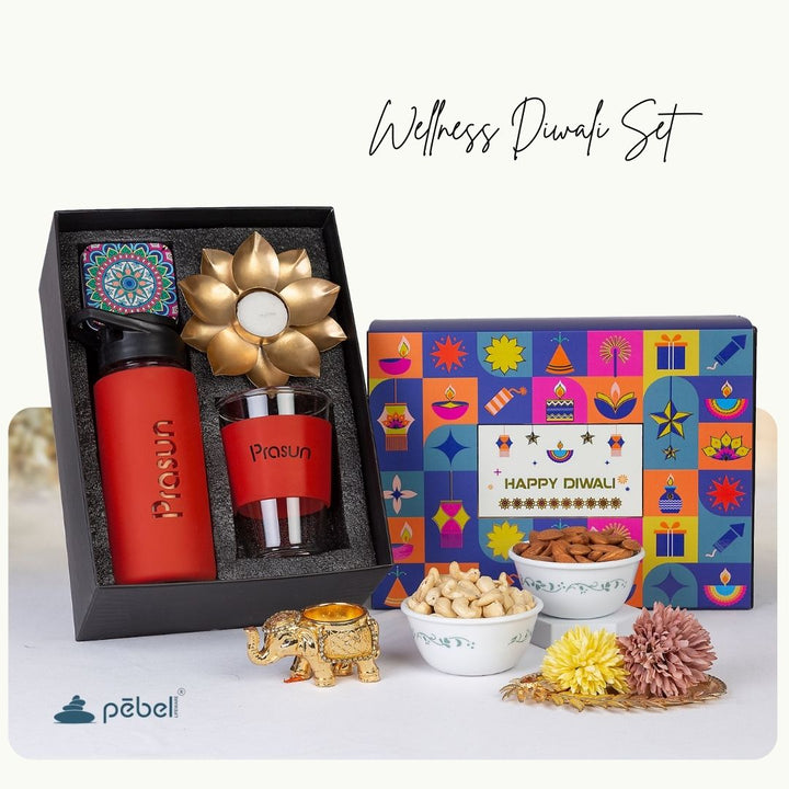 Wellness Diwali set with red tumbler, gold candle, and decorative items on a white background.